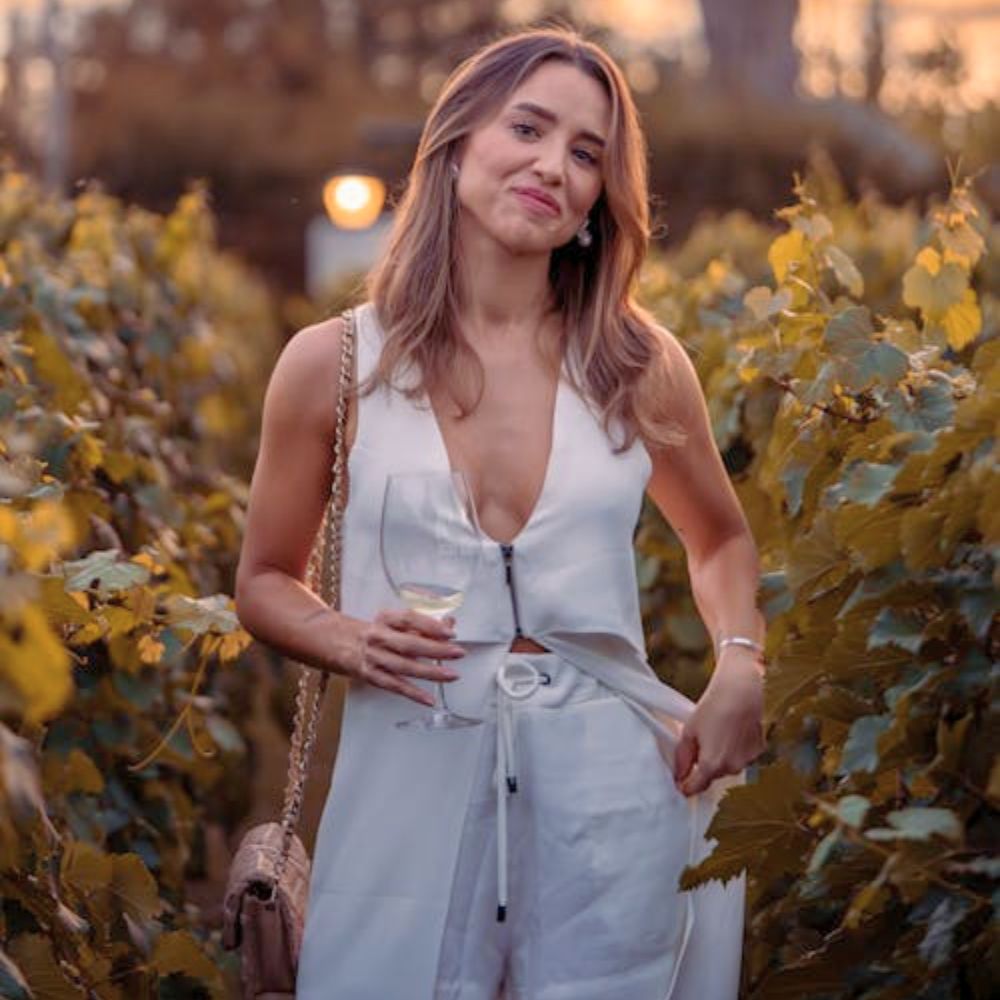 A woman standing in an Italian garden wearing a garden party dress